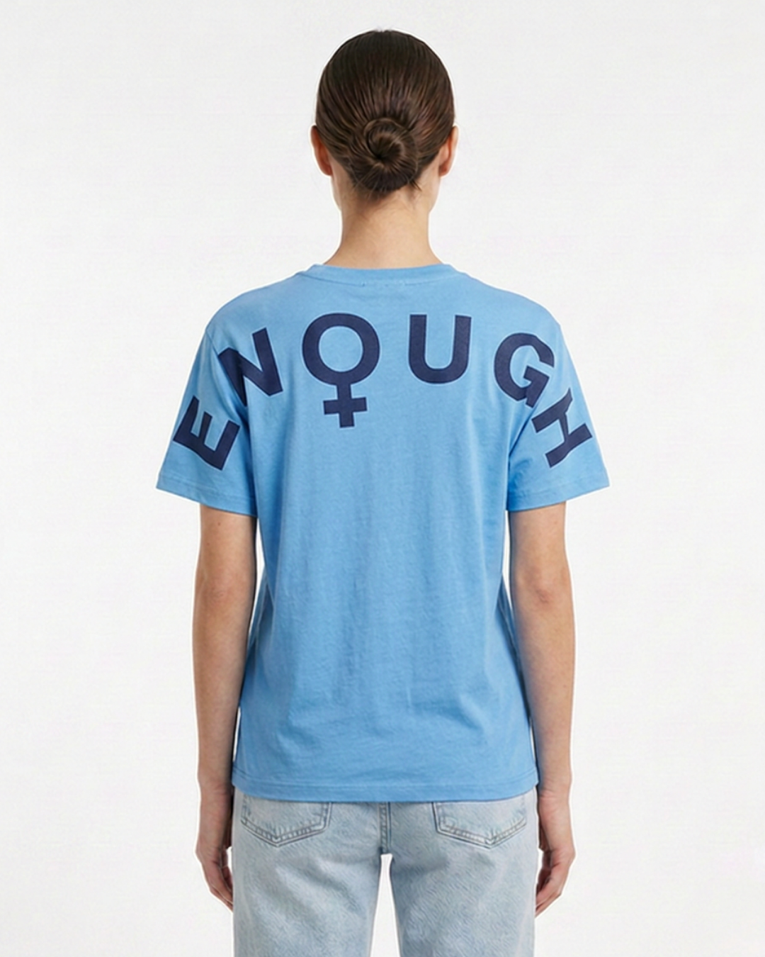 Person wearing a blue t-shirt with 'ENOUGH' text on the back, standing against a white background