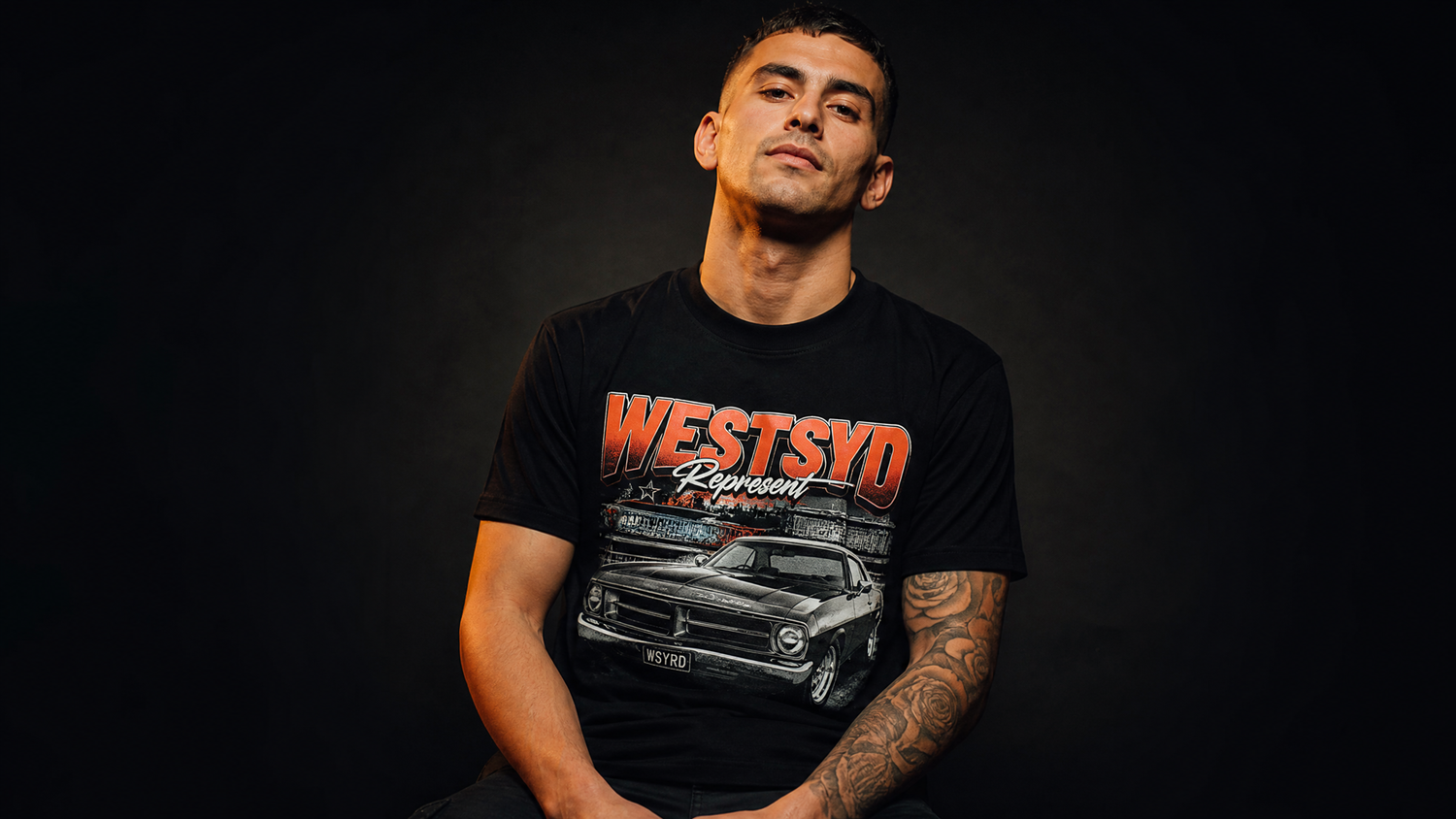 Man wearing a black t-shirt with a graphic design and text on a dark background