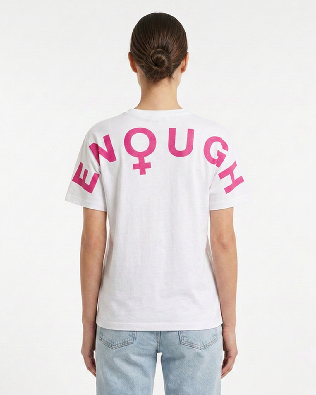 Person wearing a white t-shirt with pink text and symbols on the back, standing against a plain background.